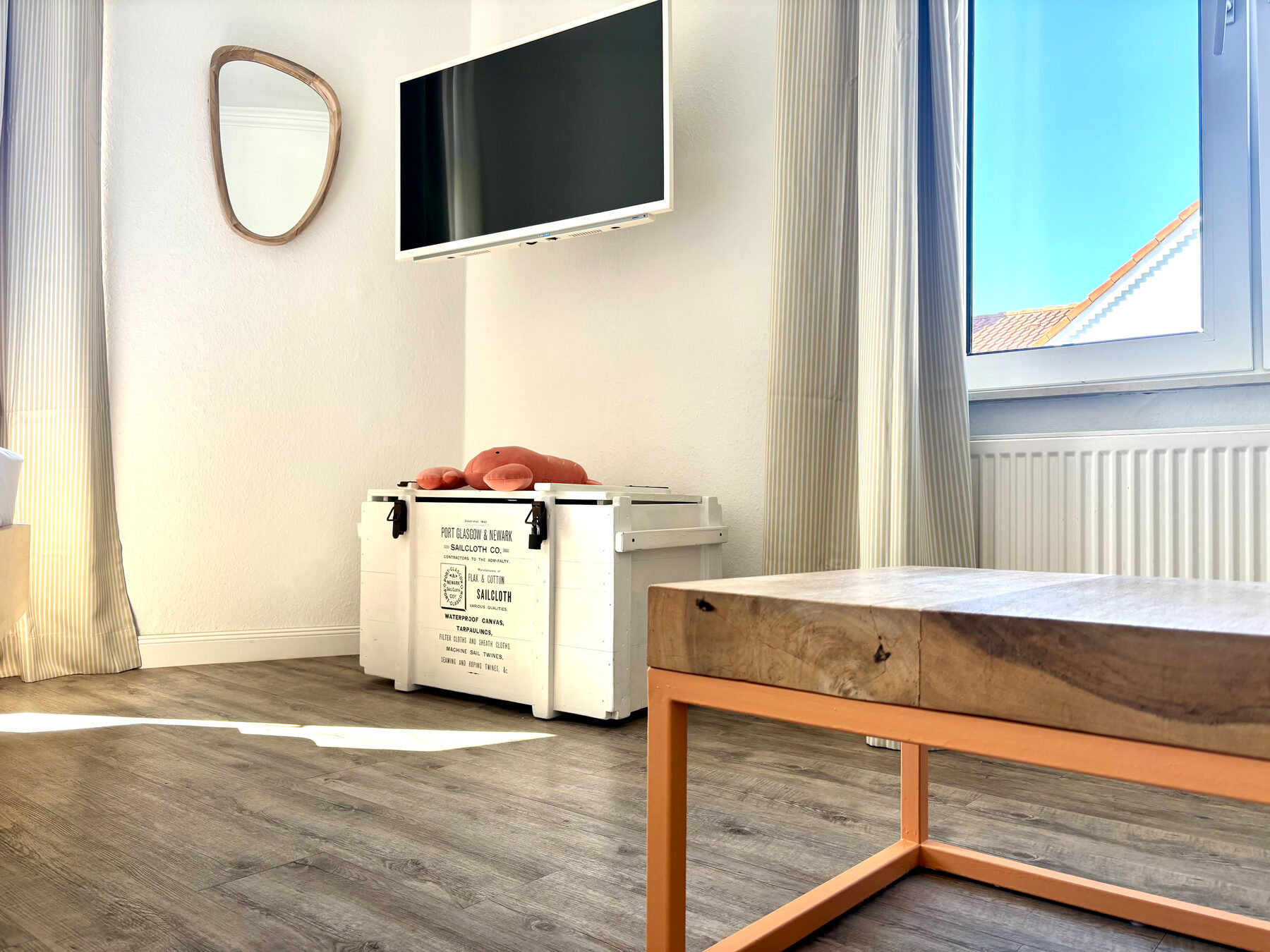 Sitzecke mit TV, Spiegel und maritimer Deko-Krabbe